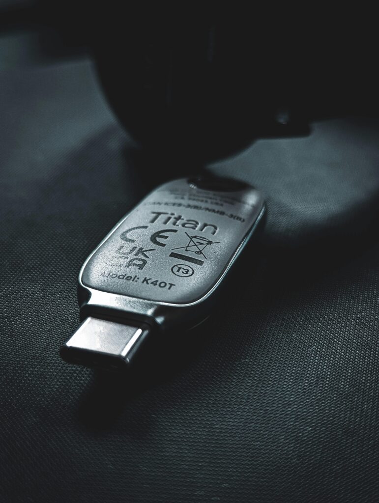 A sleek USB-C security key lies on a textured dark surface, emphasizing modern technology.